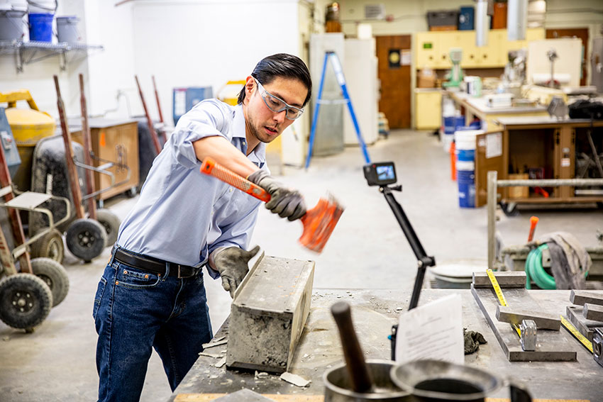 Julian holding a mallet in a lab