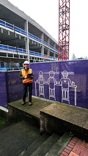 standing in construction orange in front of building under construction