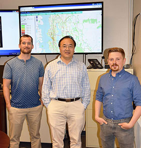 researchers in front of a map