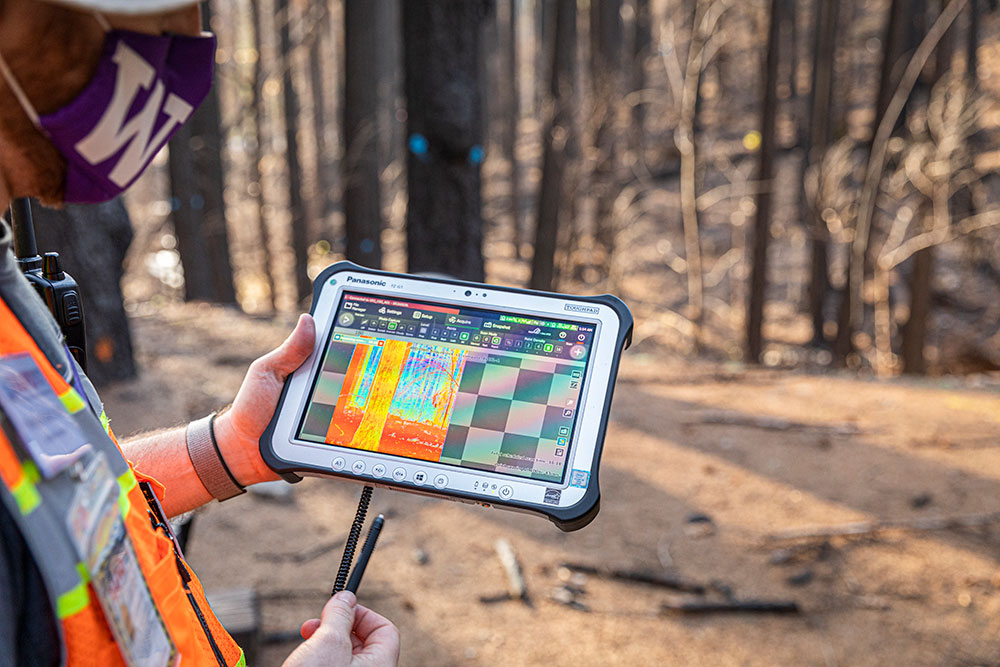 Researcher holding a tablet displaying data from laser scanning