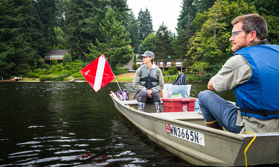 Graduate student Samantha Fung sitting in a boat with professor Alex Horner-Devine on a lake