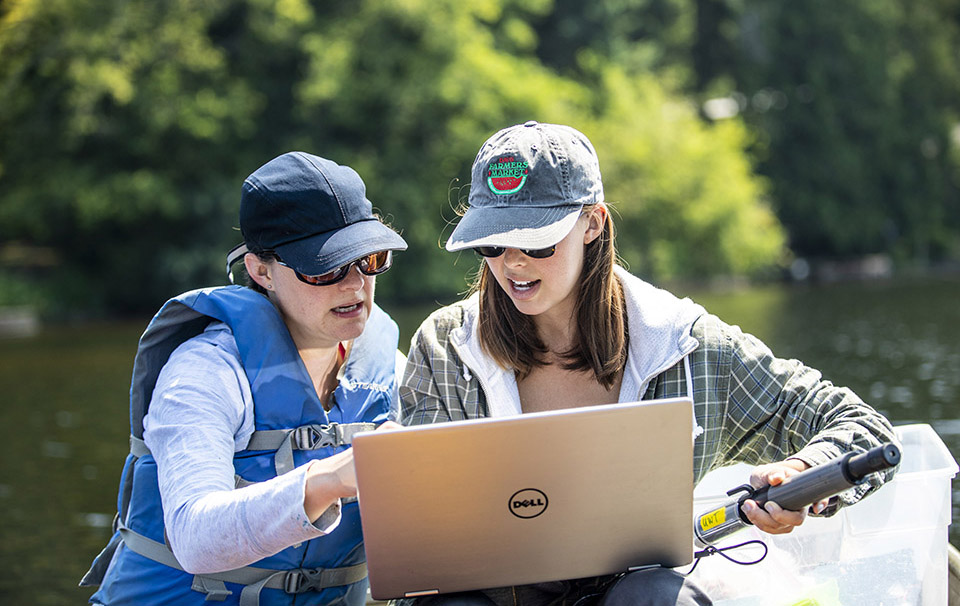 Associate professor Rebecca Neumann and graduate student Samantha Fung looking at a laptop screen together