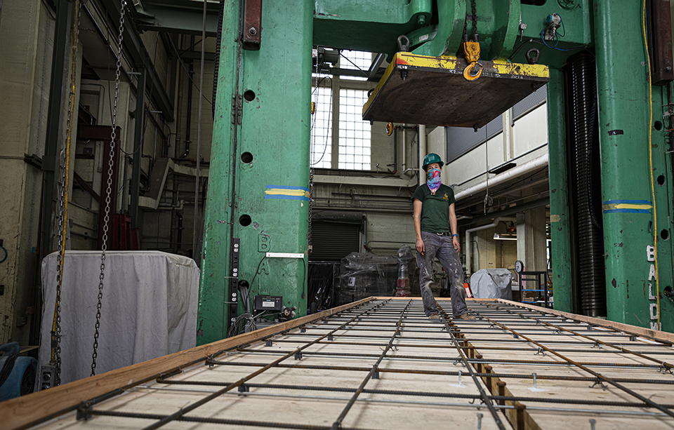 KPFF structural design engineer Addie Lederman stands on the composite beam specimen underneath the Big Baldwin platen