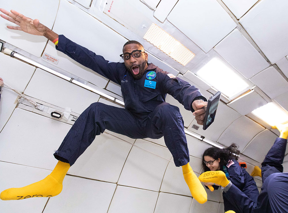 Okereke floating in the air in a zero gravity flight