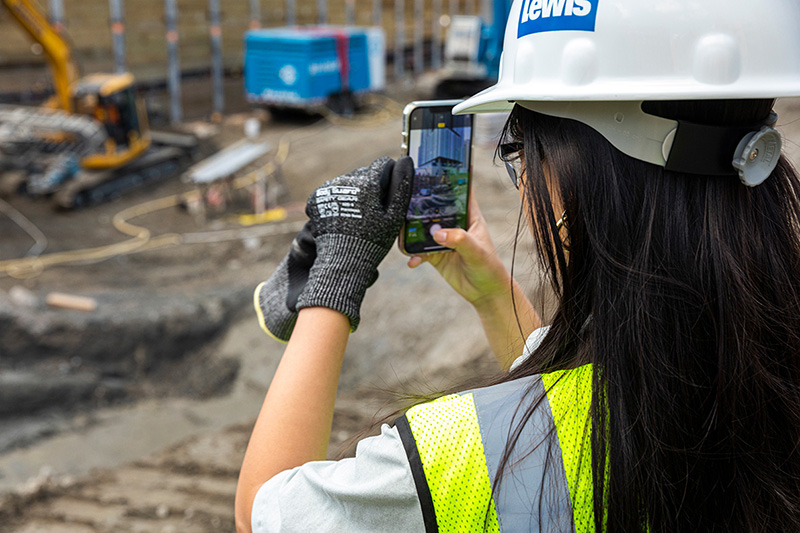 Nancy Le taking a picture of a construction site using her phone