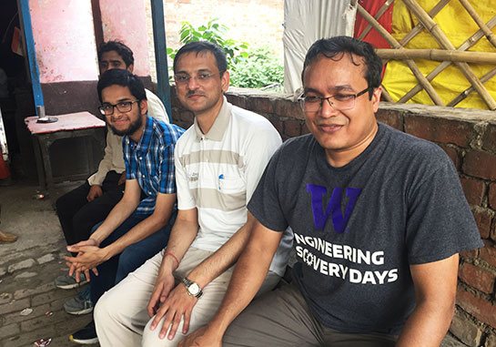 professor Faisal Hossain sitting with three other researchers in a room