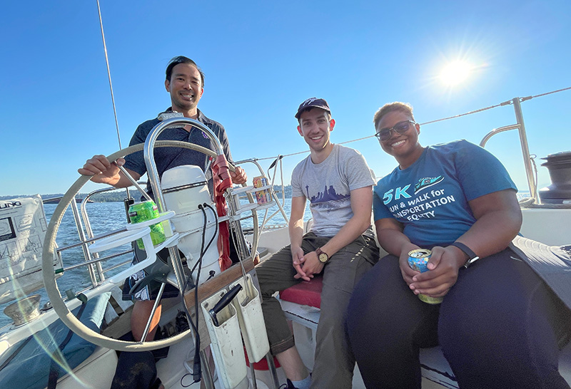 Steffen Coenen sitting on a sailboat with two of his colleagues