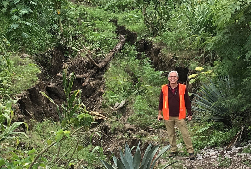 Pedro Arduino stands near the scarp of a landslide
