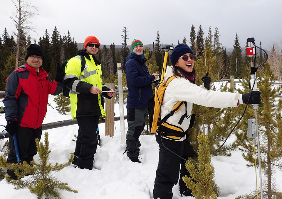 photo of Victoria Ly taking snow depth measurements with three others