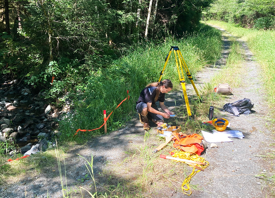 Matthew Bonner making some calculations next to a stream