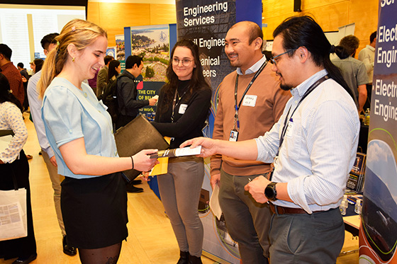 A student shaking hand with an employer at a career fair