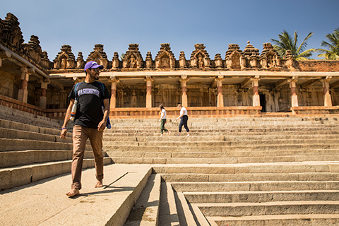 A student walking in what looks to be an ancient Indian temple