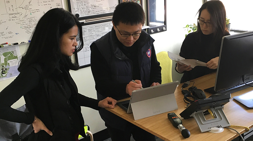 three researchers around computer