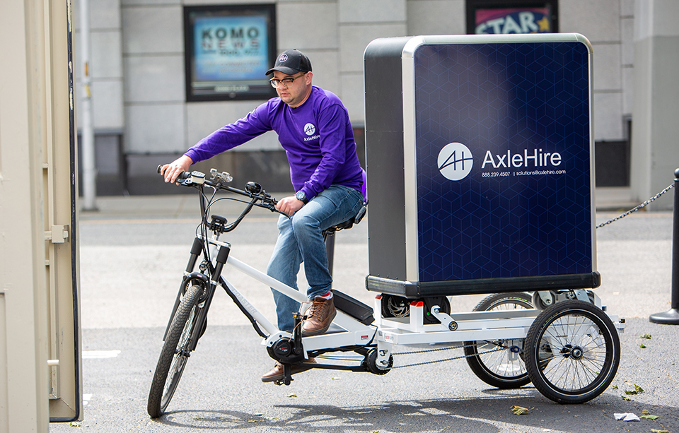 A researcher riding a three-wheeled electric bike