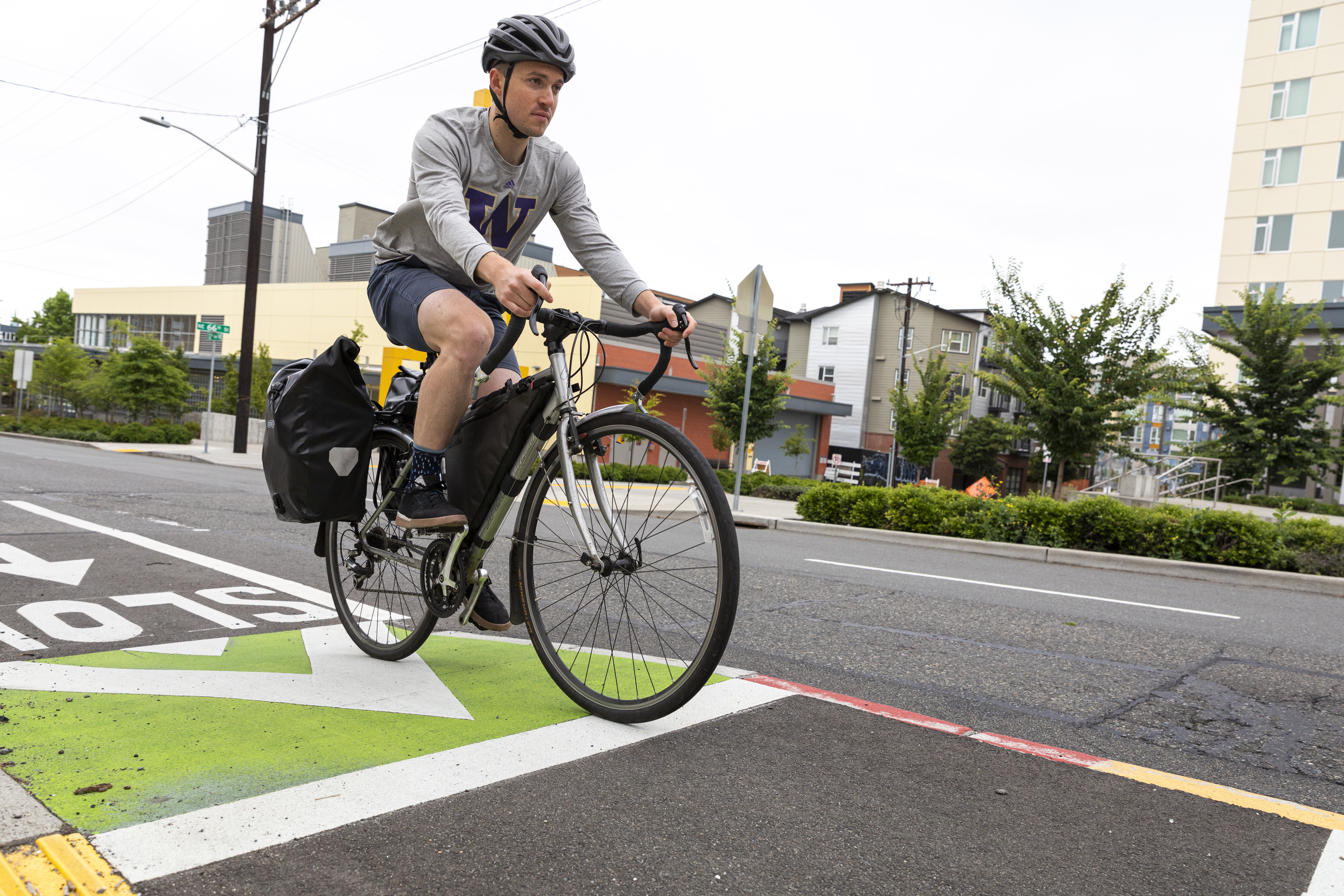 A man bikes in a bike lane on a city street.