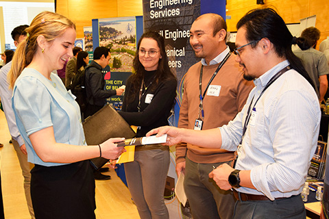 student receiving a flyer at the Career Fair