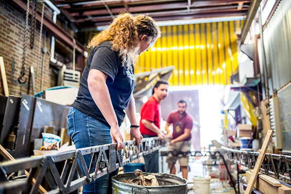 Three students carrying a steel beam