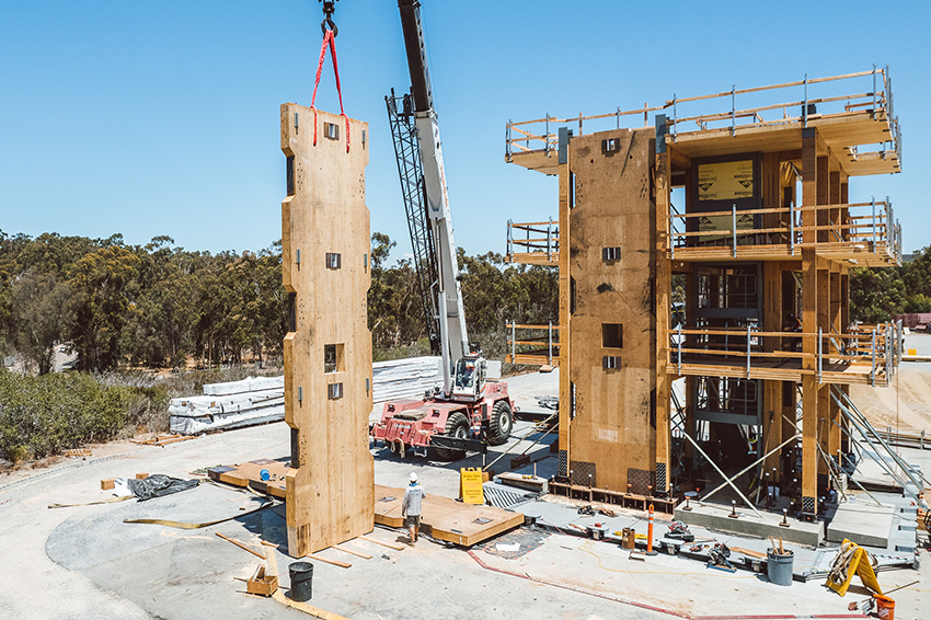 A rocking wall being lowered into a mass timber building