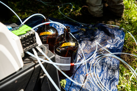 Two dark glass bottles connected to an electronic device by plastic tubes