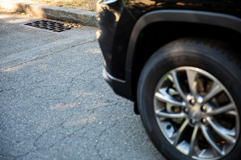 A car parked next to a water drainage