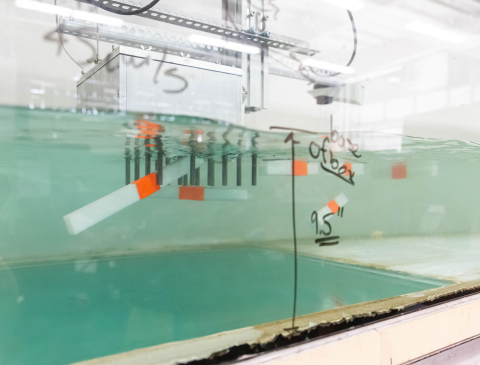 A tank of water with rectangular white and orange devices floating inside