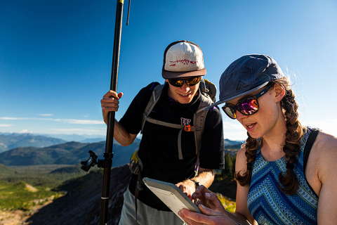 CEE Ph.D. students Seth Vanderwilt and Hannah Besso looking down at a surveying device