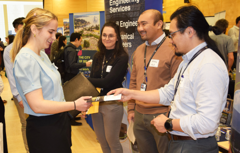 An undergraduate student accepts a flyer