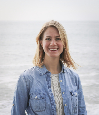 Christie Hegermiller stands on a beach with the ocean behind her.