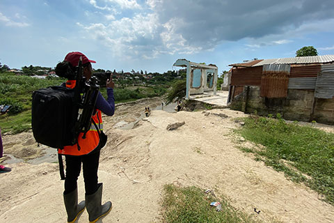 A researcher uses RAPID equipment to capture data on a flood-damaged housing structure in Dar es Salaam.