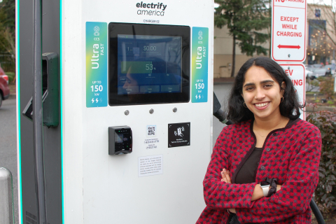Civil and environmental engineering graduate student Rubina Singh stands next to an EV charging station. 