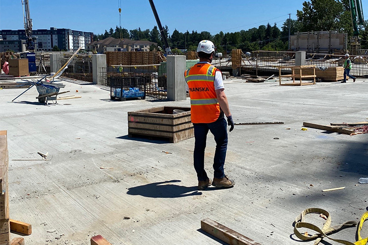 Person wearing an orange vest and hard hat at a construction site