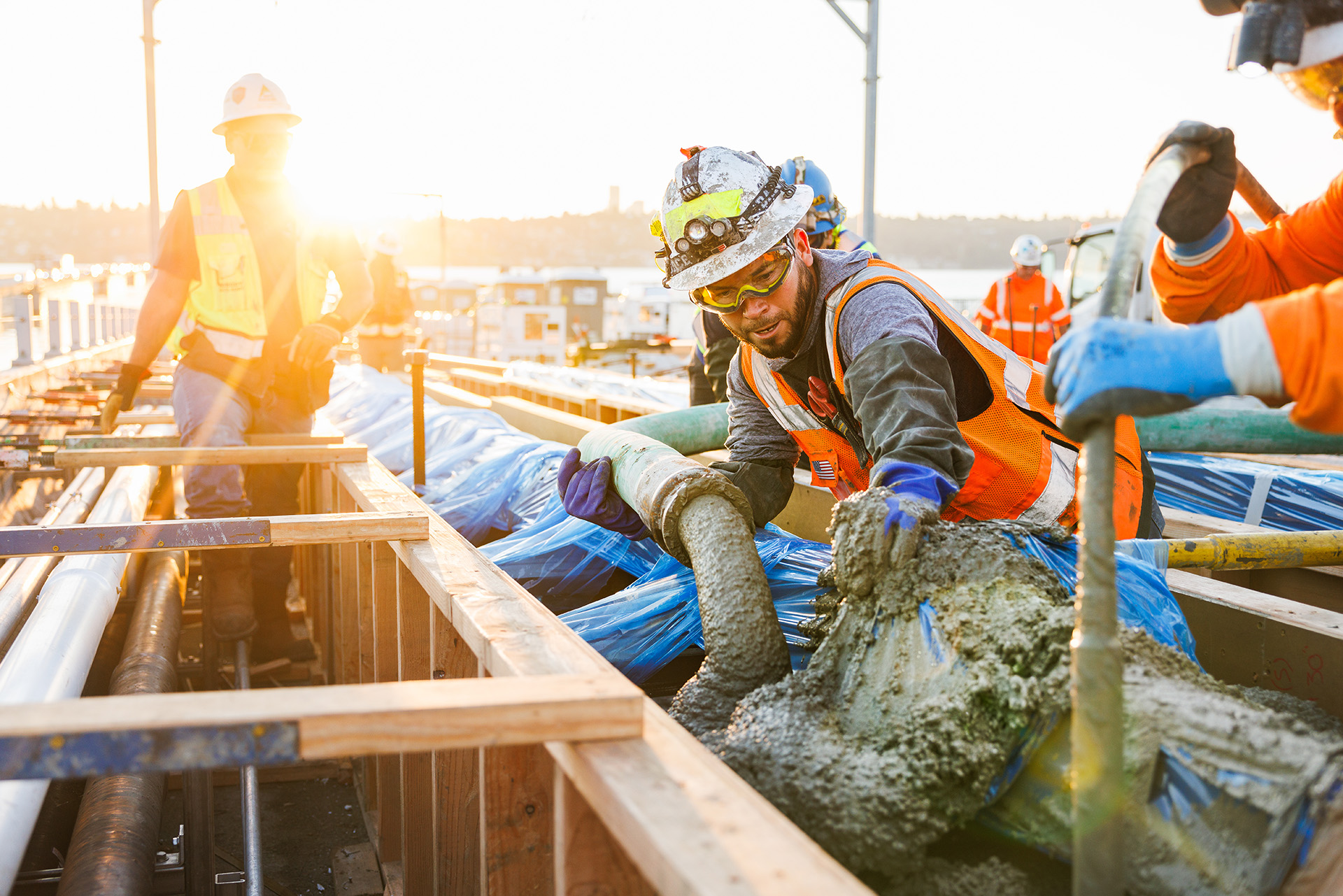 Close up of construction workers pouring concrete at a site 