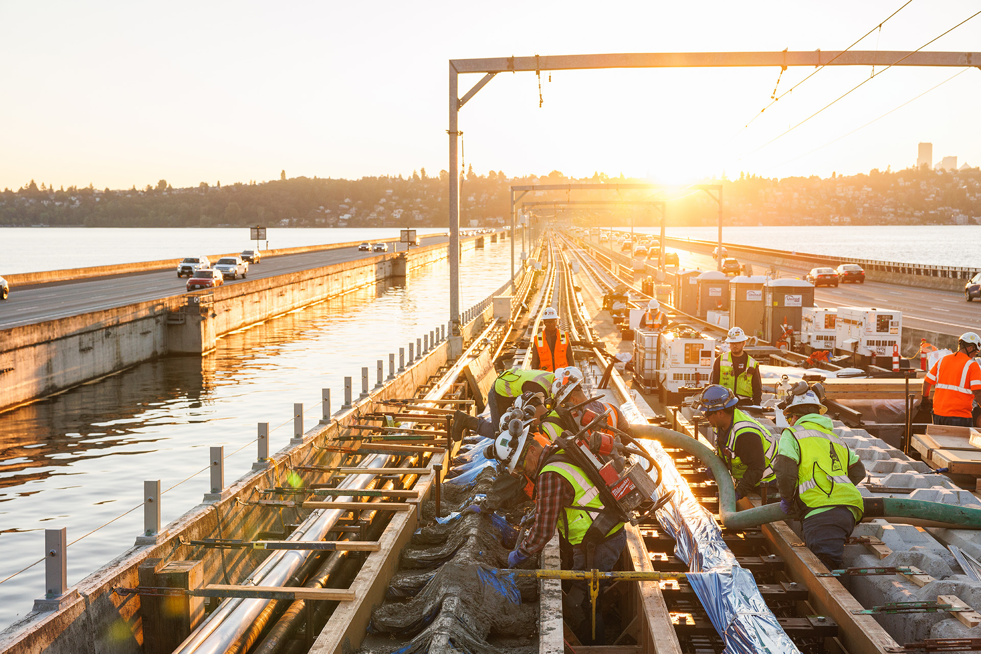 Construction workers on a bridge at sunset