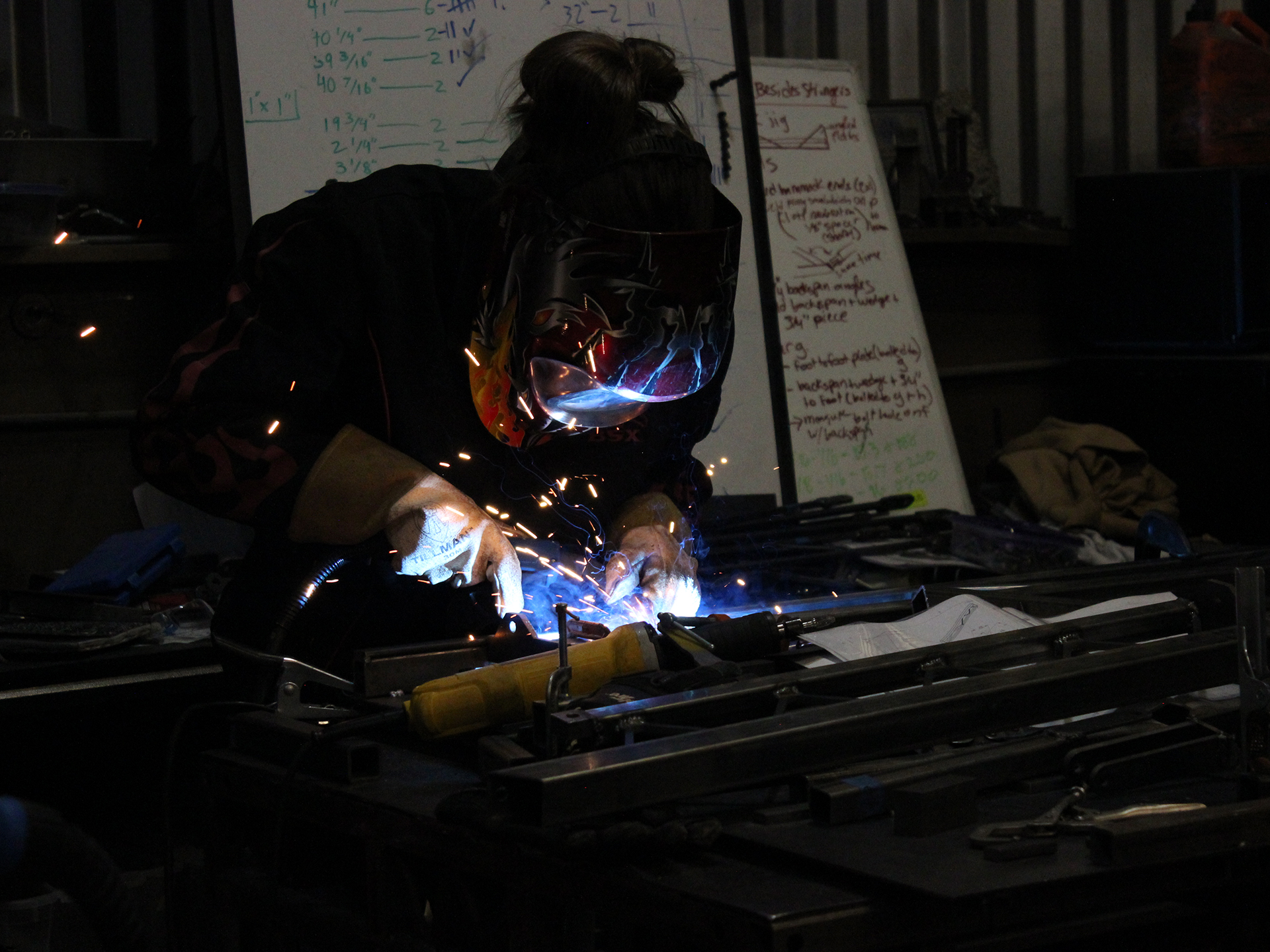 A person welding metal in a workshop