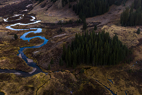 Aerial view of the East River watershed, a tributary of the Colorado River, winding through mountains and forests.