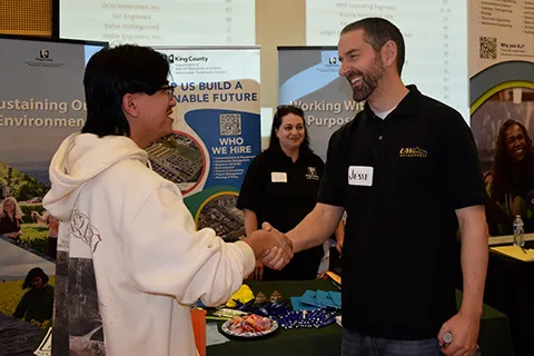 Two people shaking hands at a career fair