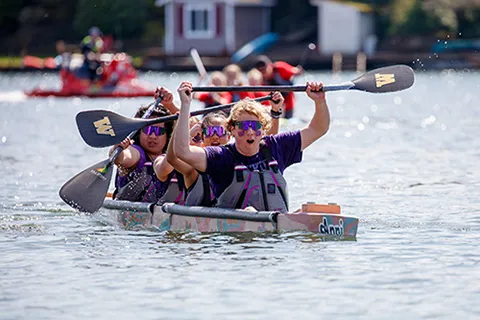 Concrete Canoe team members raise their paddles in celebration after winning the Pacific Northwest ASCE Student Symposium, where they placed first in every race and earned a spot at nationals.