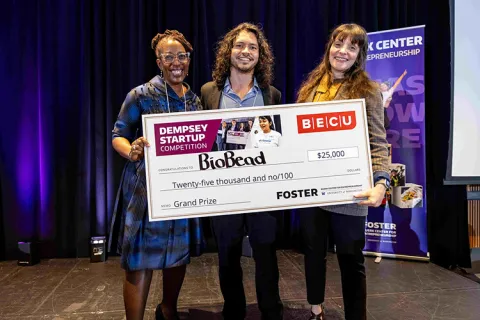 Three students holding a large check made out to BioBead.