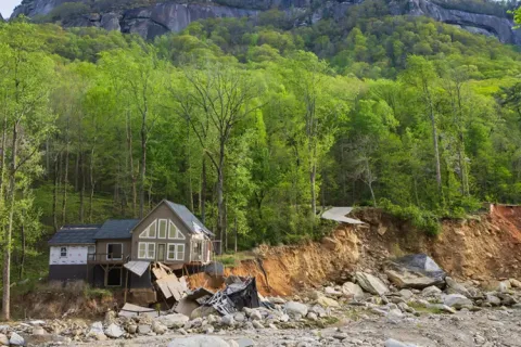 A home standing atop a collapsing river bluff in North Carolina after Hurricane Helene.