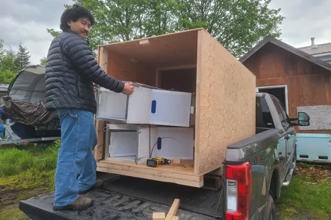 A researcher unboxes remote fish monitoring chutes.
