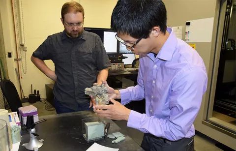 Randall Irmis watches as CEE ​lab manager Sean Yeung prepares a marine crocodilian skull to be scanned