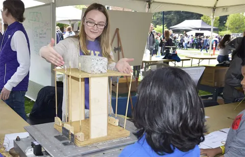UW student demonstrating a device to a young student