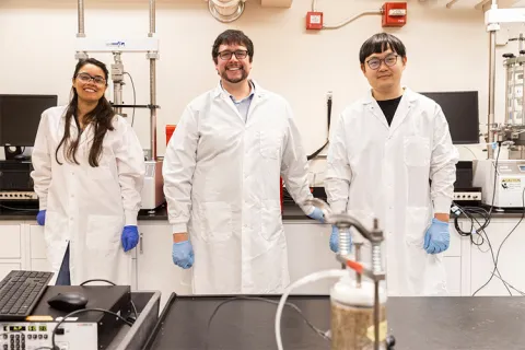 Three people in lab coats in a laboratory