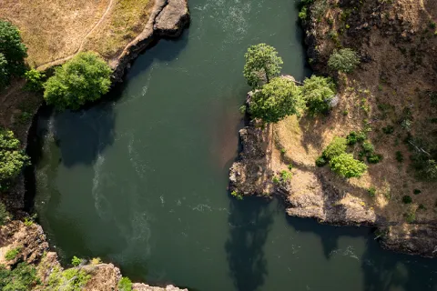 Aerial view of a winding river flowing between rocky banks