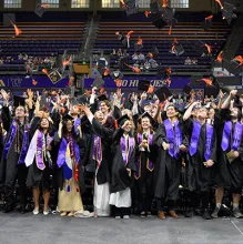 students throw caps in the air at graduation